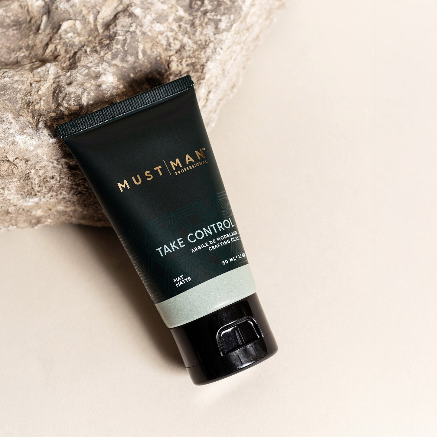 Must Man Professional Take Control Crafting Clay — 50 ml tube laid on a knitted textile, angled lifestyle shot