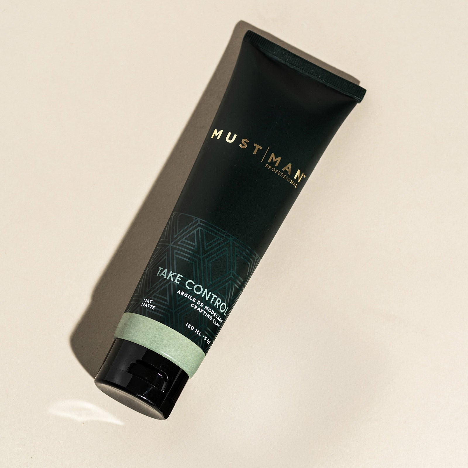Must Man Professional Take Control Crafting Clay — 150 ml tube tilted on a warm neutral background