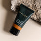 Must Man Professional Triple Duty Hair, Beard & Body Wash — 50 ml travel tube resting against a stone, lifestyle shot