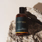 Must Man Professional Triple Duty Hair, Beard & Body Wash — 250 ml amber bottle propped on rock, lifestyle shot