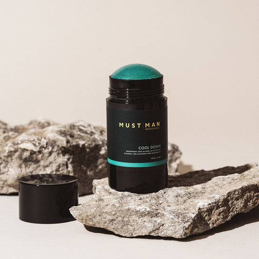 Must Man Professional Cool Down Deodorant — 75 ml deodorant stick open on stone, showing the teal balm, lifestyle shot