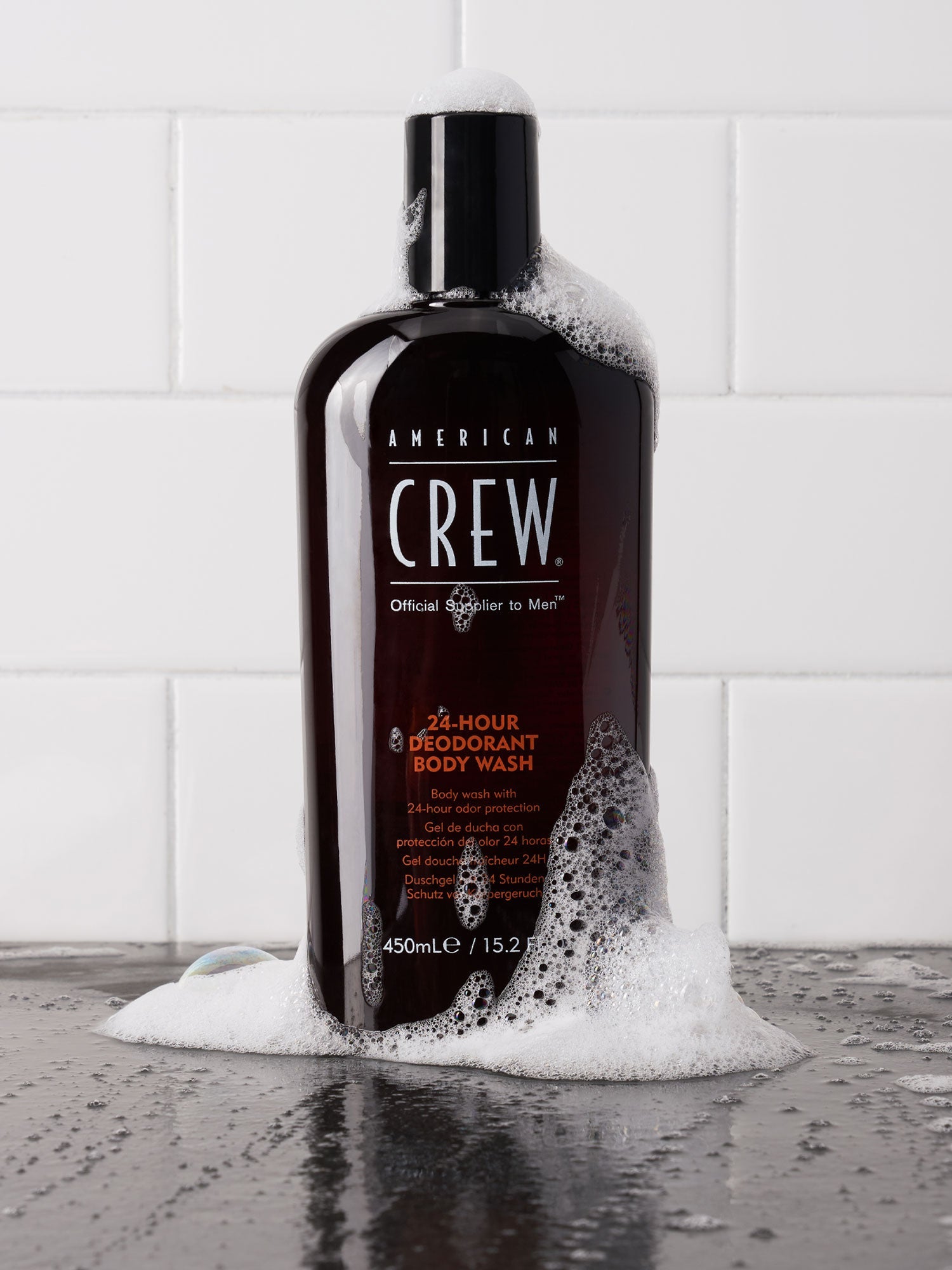 American Crew 24-Hour Deodorant Body Wash bottle in a shower setting