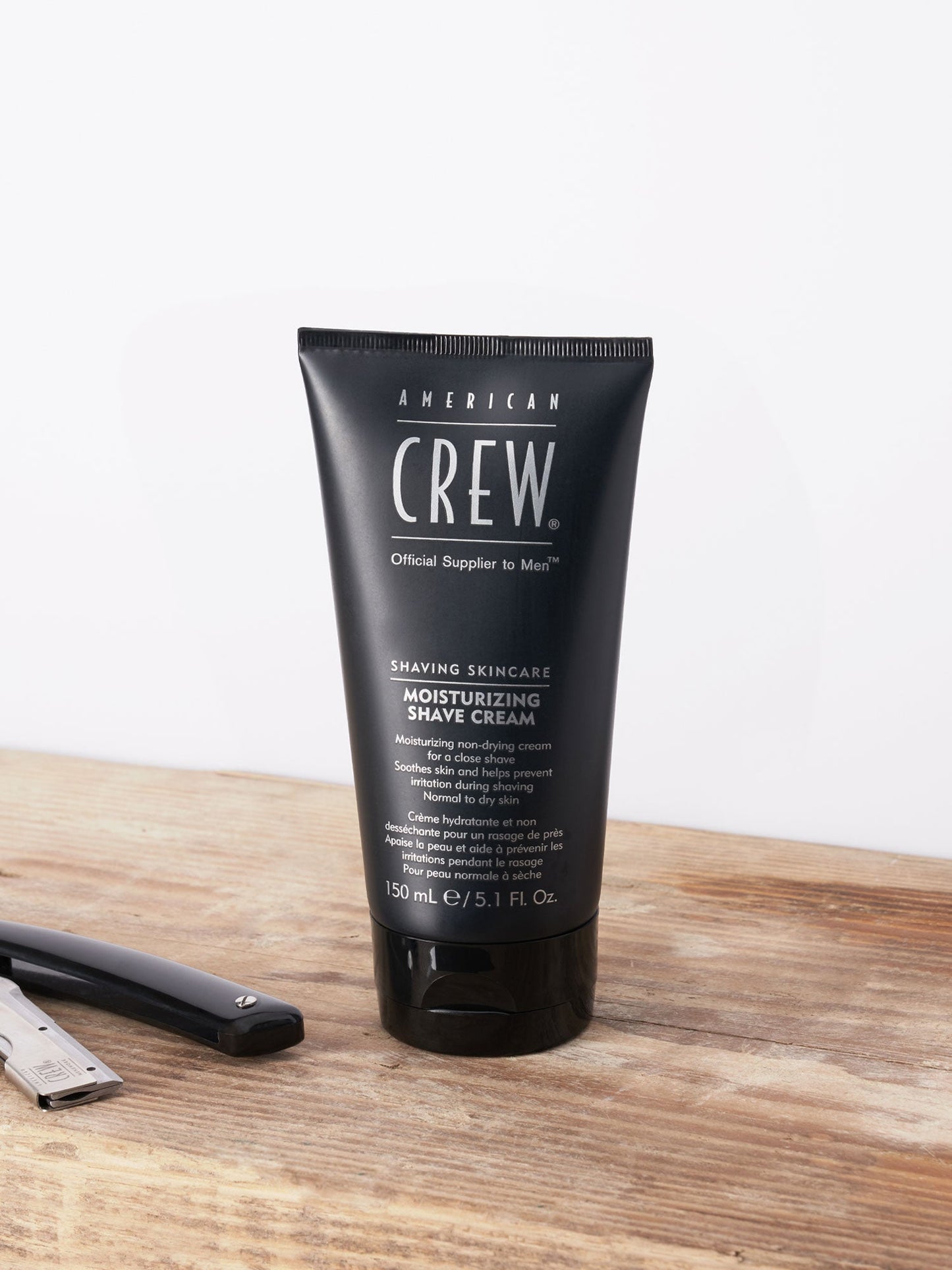 American Crew Moisturizing Shave Cream tube on a barber's counter