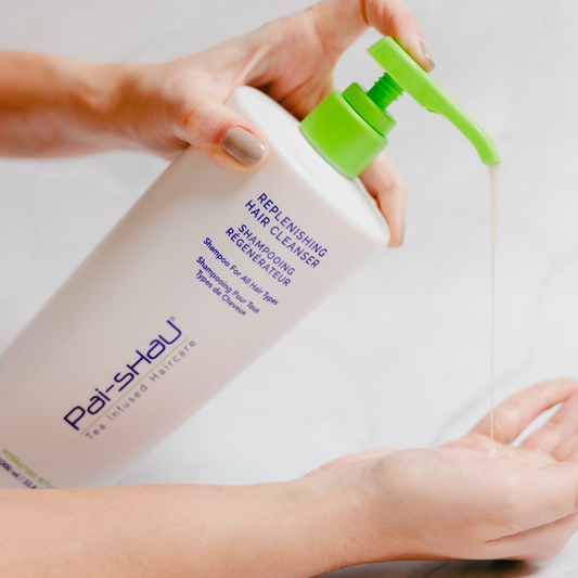 Pai-Shau - Replenishing Hair Cleanser — new-livery white 1 L bottle being dispensed by hand