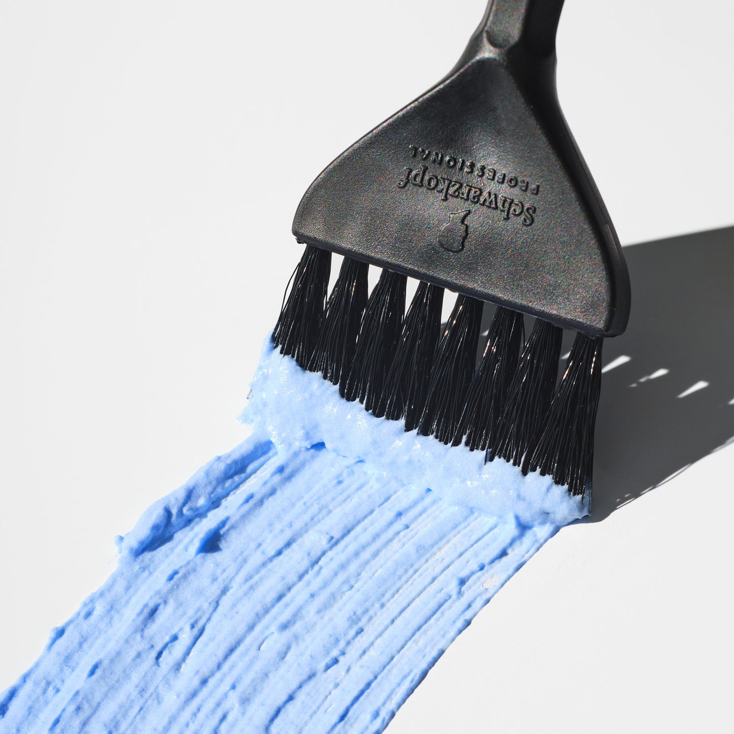 Schwarzkopf IGORA Vario Blond Plus Blue Bleach Dust Free Lightening Powder — blue lightening powder swept from a Schwarzkopf tint brush