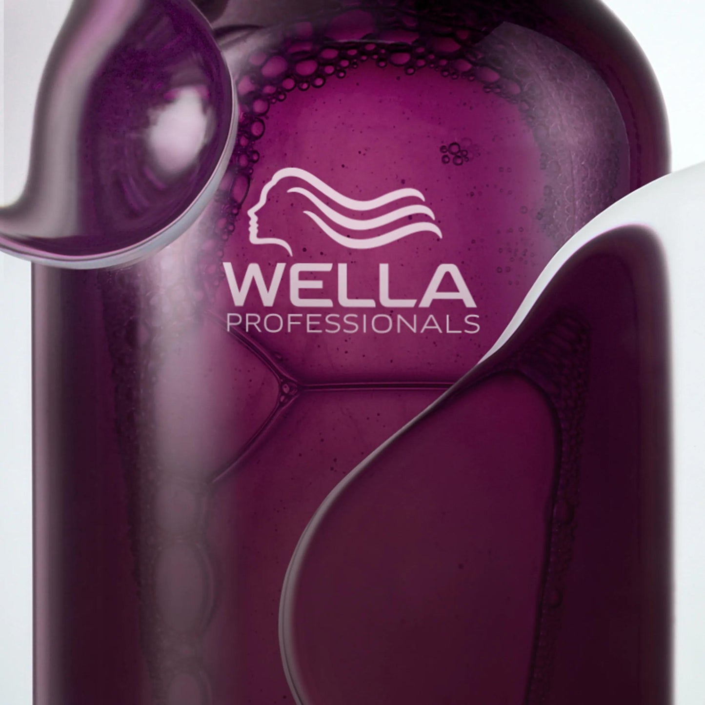 Wella Professionals Ultimate Color — Close-up image of Ultimate Color shampoo against white background. Text overlay reads "Clear shampoo with a soft foam".