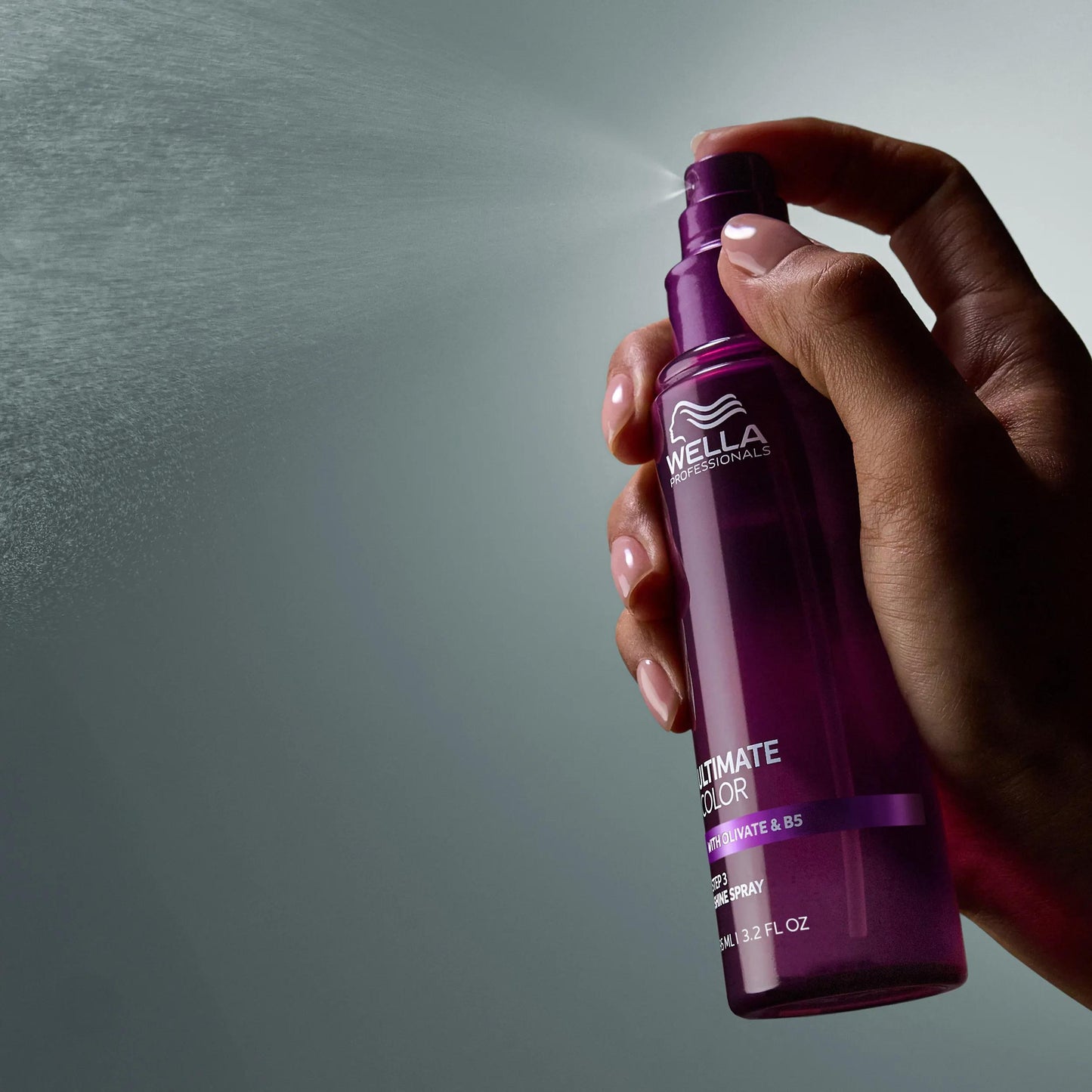Wella Professionals Ultimate Color — Image of model spraying the Ultimate Color shine spray. Text overlay reads "Mist to add shine and smoothness".