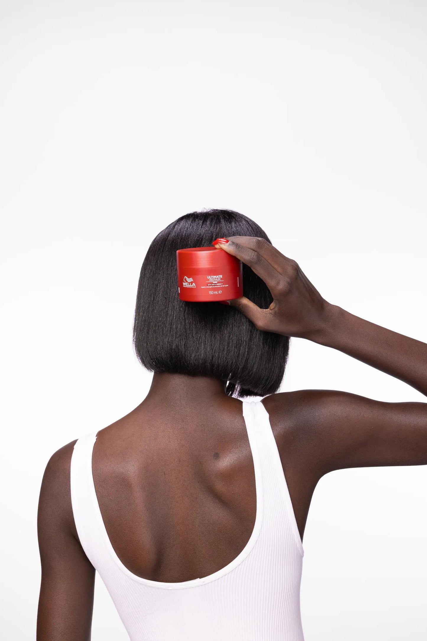 Wella Professionals Ultimate Repair — model applying the mask to a glossy bob