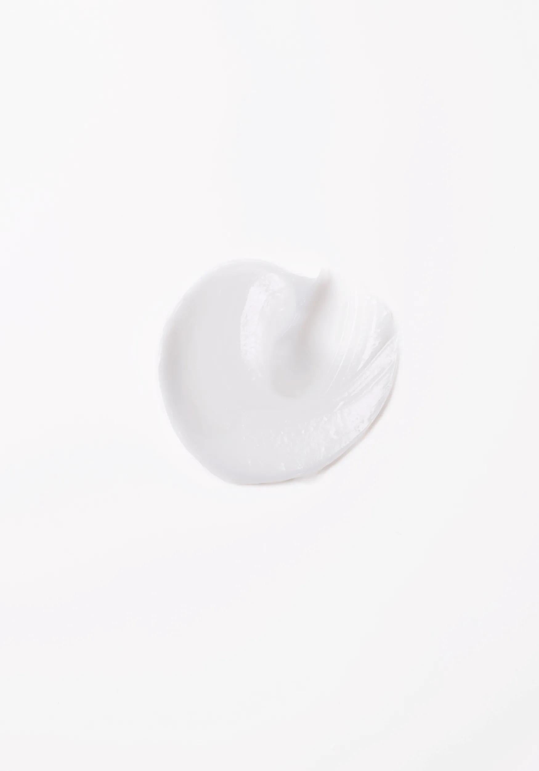 Wella Professionals Invigo Brilliance — Close-up photograph of a circular blob of Invigo Brilliance product on a white background, with text saying 'antioxidant shield, helps control the oxidation process after coloring' and 'metal purifier, protects from harmful metals in water'.