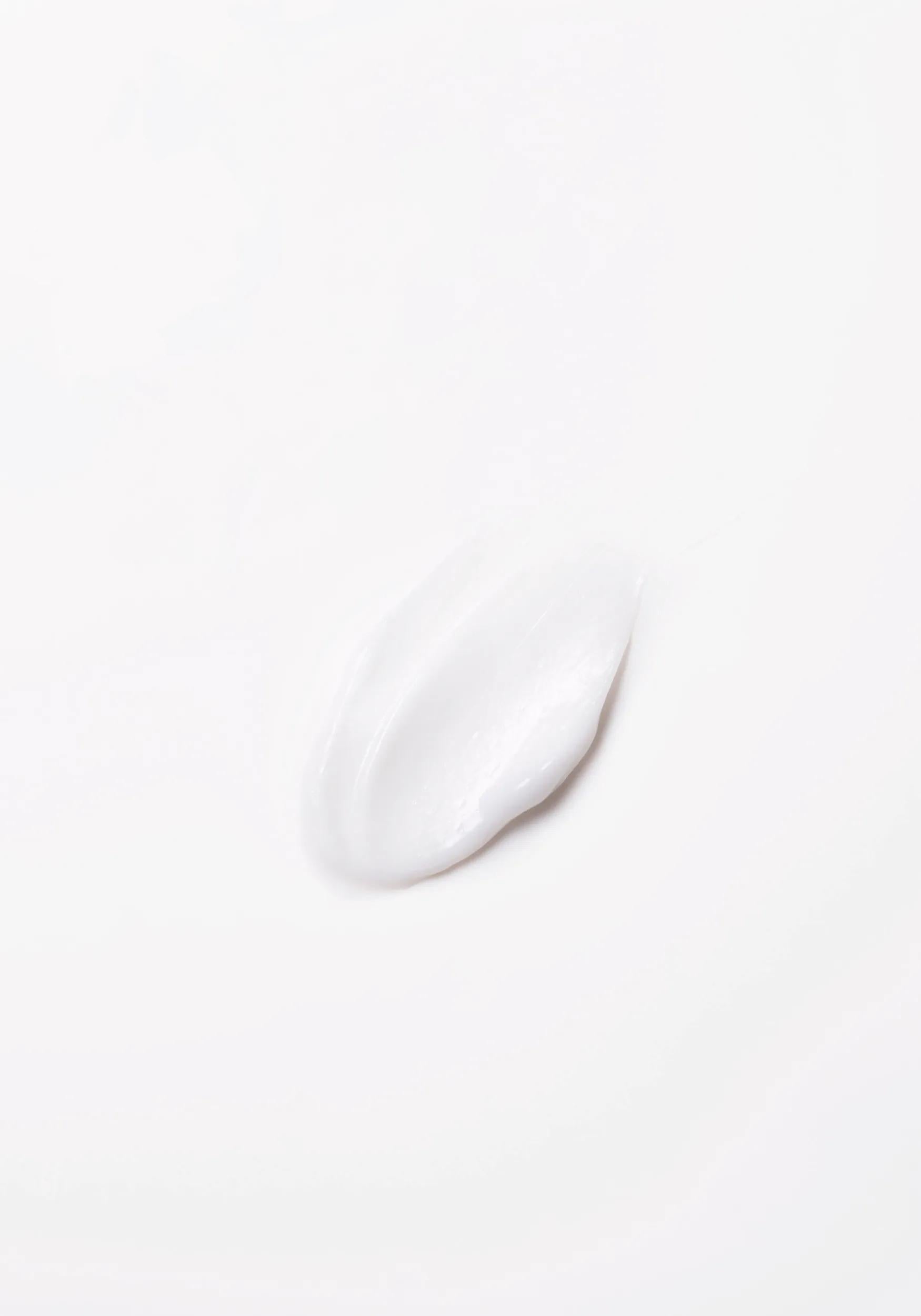 Wella Professionals Invigo Brilliance — Close-up photograph of a circular blob of Invigo Brilliance product on a white background, with text saying 'antioxidant shield, helps control the oxidation process after coloring' and 'metal purifier, protects from harmful metals in water'.