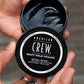 American Crew Heavy Hold Pomade — open 85 g tub held in hand showing the dark pomade texture, water-based formula